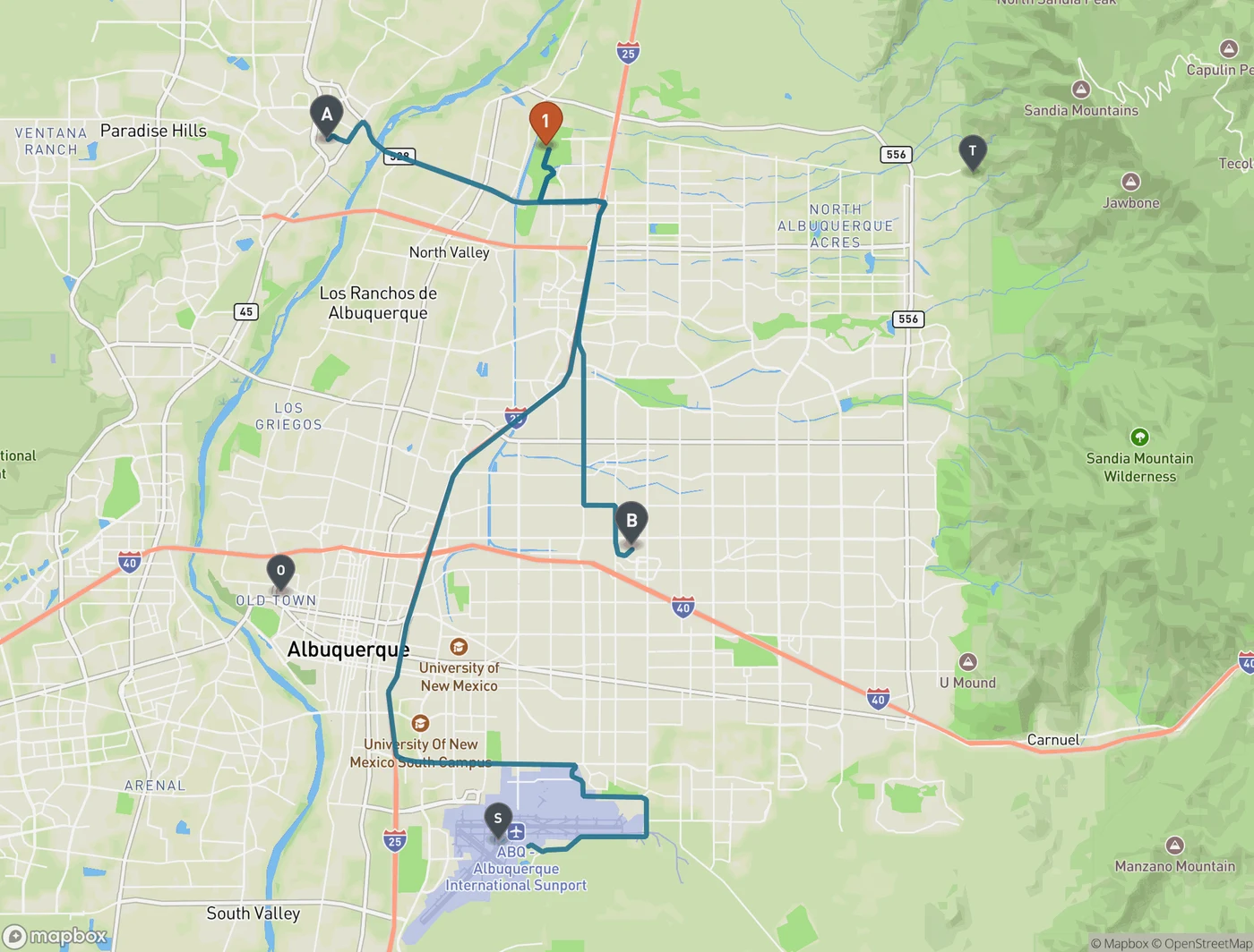 Orientation map of Albuquerque showing Balloon Fiesta Park marked 1 on the city's northern edge just west of Interstate 25, with driving routes drawn from A, Cottonwood Mall in the northwest, B, Coronado Center in the midtown area, and S, the Albuquerque International Sunport in the far south. O marks Old Town west of downtown and T marks the Sandia Peak Tramway in the foothills to the east.